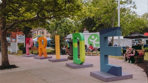 Sculpture of the word PRIDE on the sidewalk in front of the South Green at Union Park
